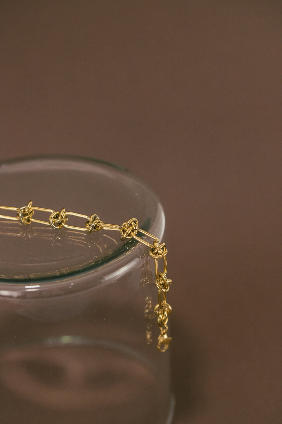 a close up of a gold chain on a glass container
