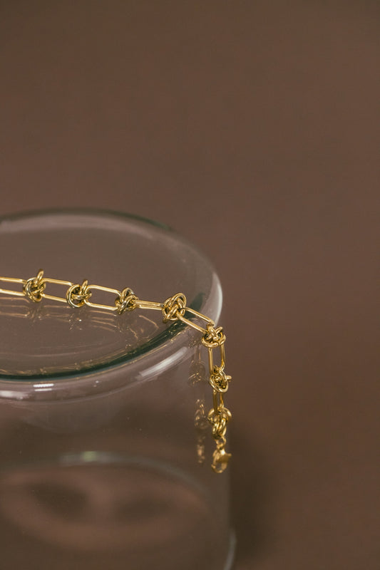 a close up of a gold chain on a glass container
