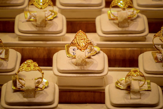 Rows of ornate gold rings displayed on stands.
