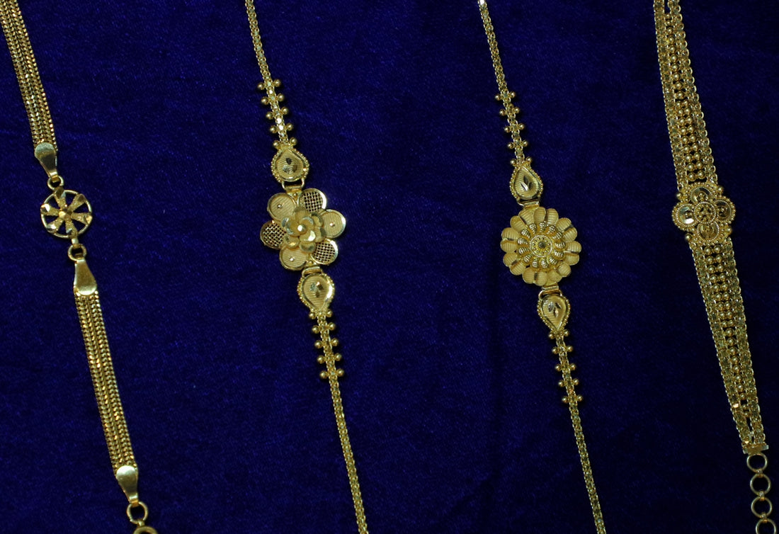 Four delicate gold bracelets on blue velvet